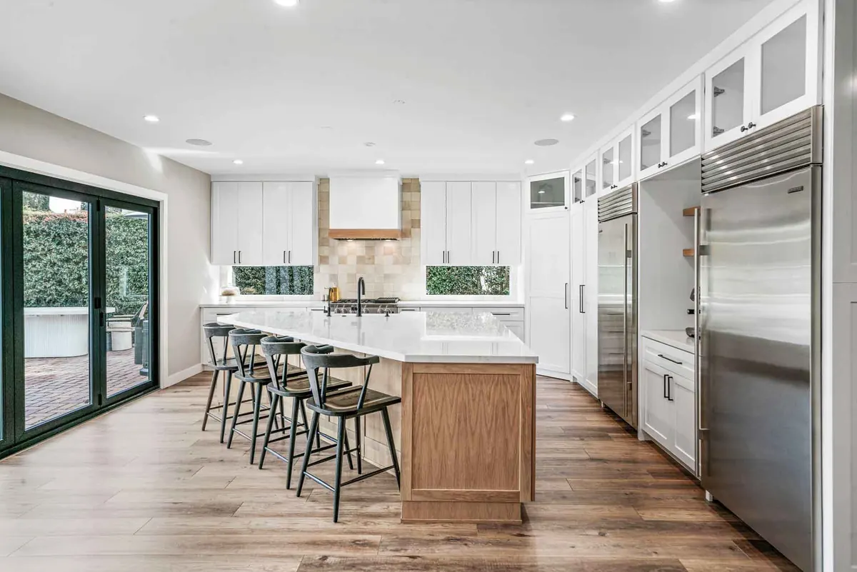 Contemporary kitchen redesign with wood cabinetry and stone counters