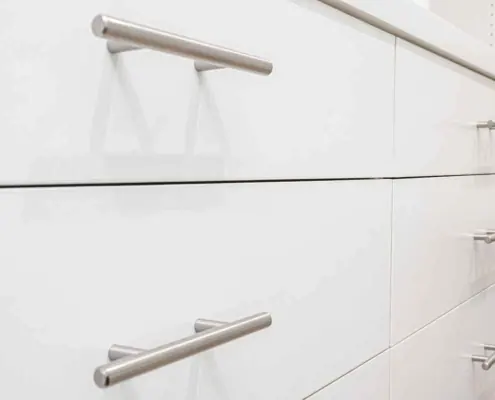 Brushed nickel handles make a statement with clean lines and a flattering white backdrop provided by the drawers.